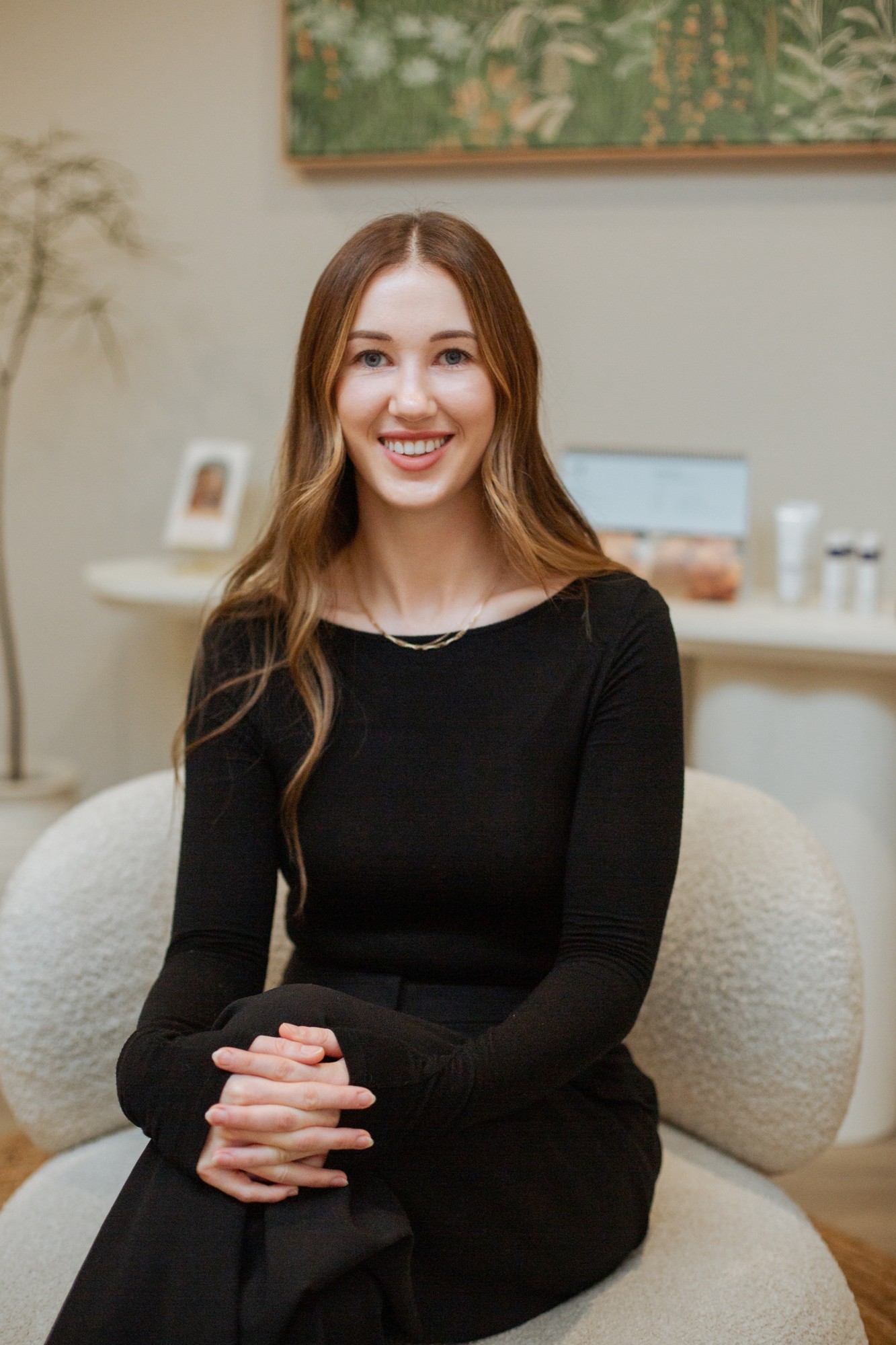 Gabriella smiling, seated in the Jab Lab Melbourne clinic